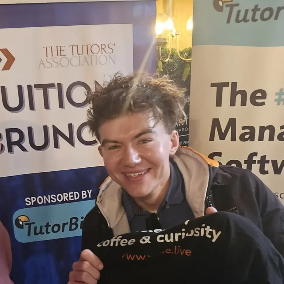Robin Gibbons, Latimer Tuition's Founder & CEO smiling in front of a banner.